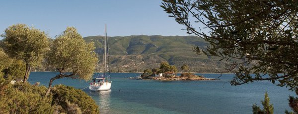 Moored yacht and the chapel on Nisos Dhaskalia, Poros